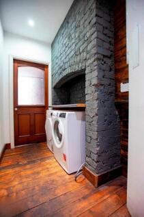 Stylish utility area with washer and rustic bri...