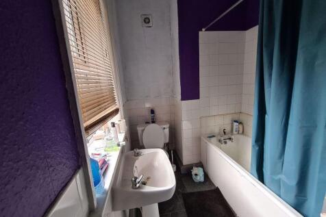 A neat and functional bathroom featuring a whit...