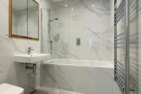 Modern bathroom with marble-effect tiling, a ba...