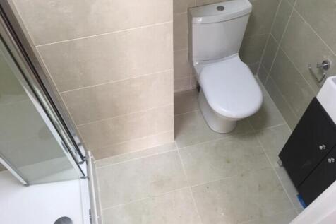 Modern tiled bathroom with a corner shower encl...