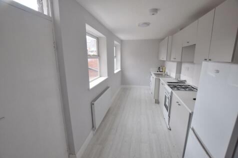 Bright galley kitchen with light wood-effect fl...