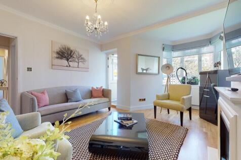 Bright, stylish living room with a large bay wi...