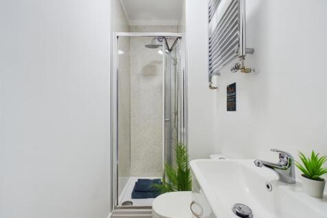 A clean, modern bathroom with a large shower ar...