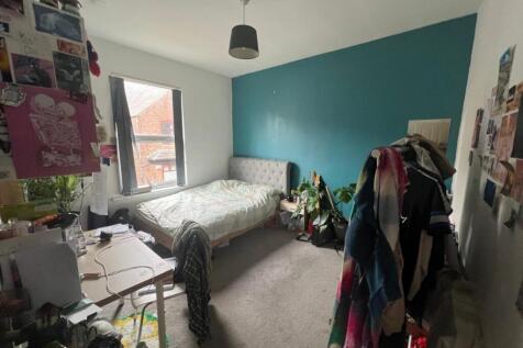 Bright double bedroom with desk and feature wal...