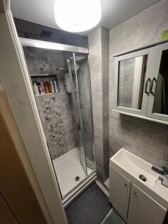 Modern tiled shower room with mirrored storage...