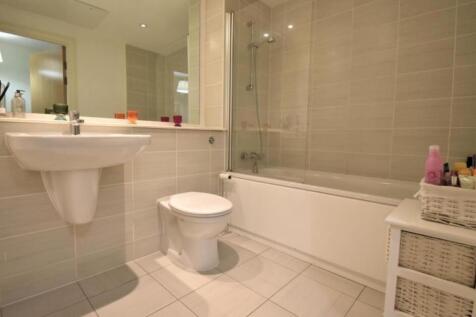Modern bathroom with full tub and stylish tilin...