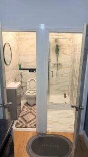 Modern marble-effect bathroom with walk-in show...