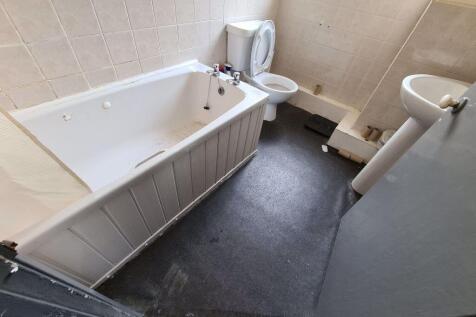 A bright and clean bathroom suite featuring a s...