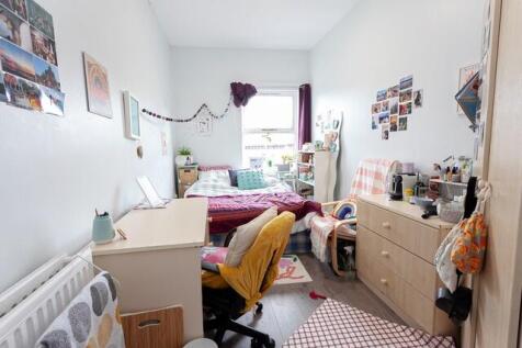 Bright, cozy bedroom with a comfortable bed, st...