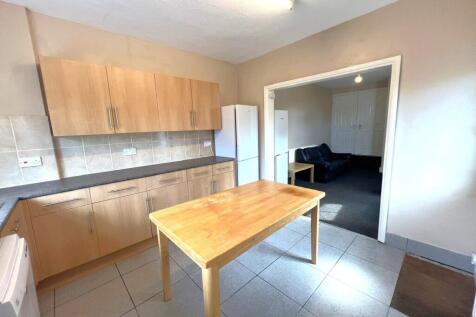 Bright kitchen with light wood cabinets, tiled ...