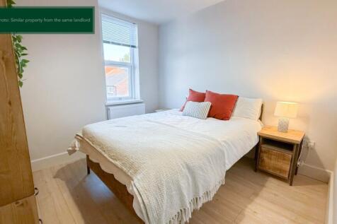 Bright bedroom with double bed and wood floors...