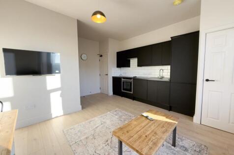 Modern open plan living with sleek black kitche...