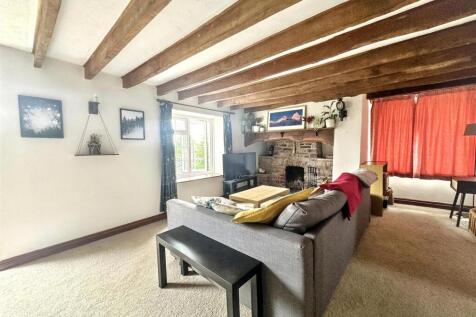 Charming living room with rustic wooden beams...
