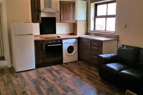 Open-plan kitchen area with fitted cabinets, in...