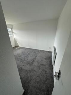 A clean and freshly carpeted single bedroom fea...