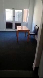 A simple living room featuring a windowed door ...