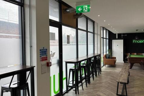 Bright communal lounge with bar seating and poo...