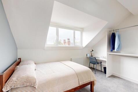 Bright and cozy single bedroom featuring a comf...