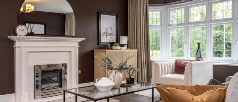 Redrow spacious lounge with large bay window compete with fireplace and stylish furnishings at Oakle