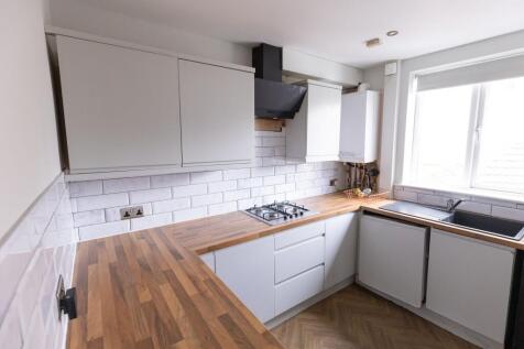 Bright and modern kitchen featuring ample white...