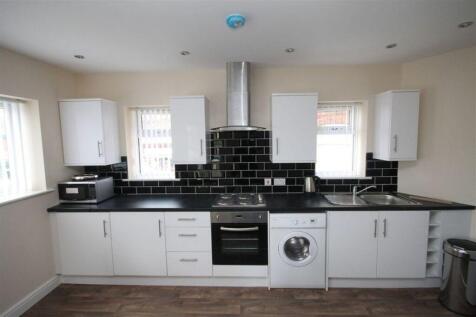 Modern kitchen with sleek white cabinets, black...