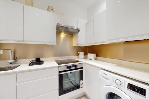 Bright modern kitchen with integrated appliance...