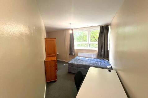 Bright bedroom with large desk and ample storag...