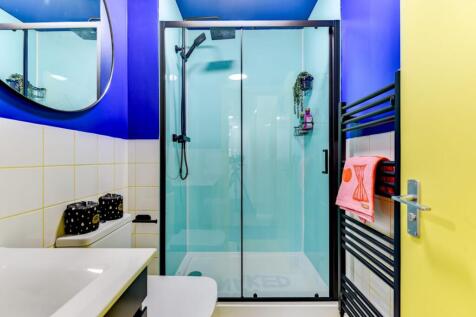 Bright, contemporary bathroom with a glass-encl...