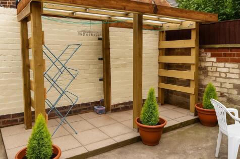 Tidy sheltered patio area with stylish pergola...