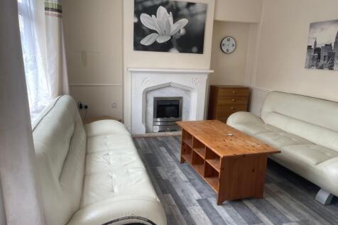 Bright living room with matching cream leather ...