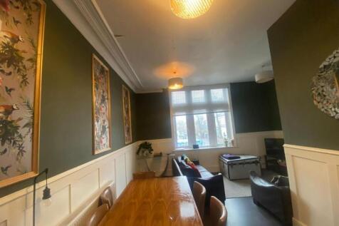 Bright, stylish living room with large bay wind...