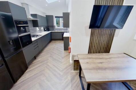 Modern sleek kitchen with breakfast bar and TV ...