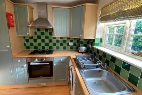 Modern kitchen with bright green tiling and win...