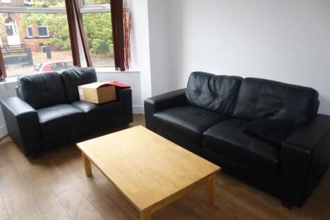 Bright living room with large windows, two blac...