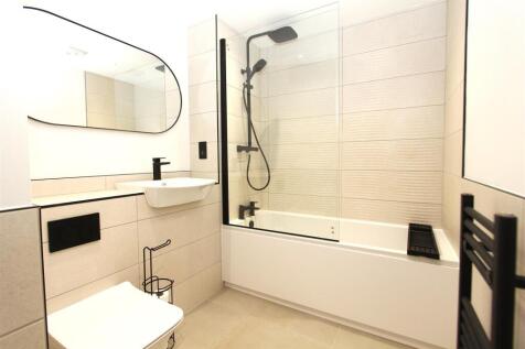 Modern bathroom with sleek black fixtures and t...