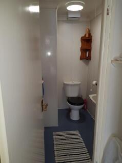 A compact, clean toilet room featuring a white ...