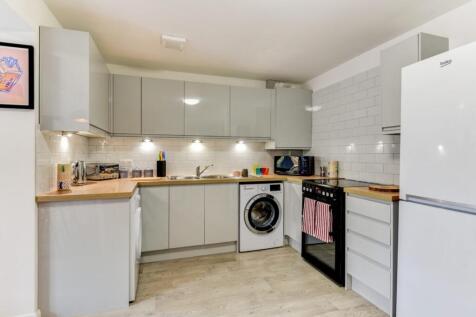 Modern fitted kitchen with glossy grey cabinets...