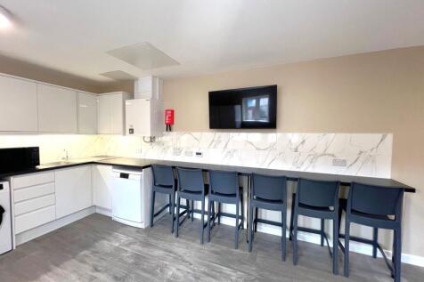 Bright, modern communal kitchen with a long bre...