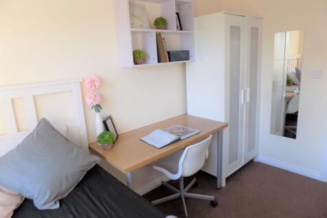 Bright, neatly furnished single bedroom with a ...