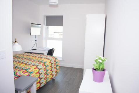 Bright modern bedroom with desk and wall-side w...