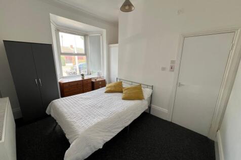 A bright double bedroom featuring a comfortable...