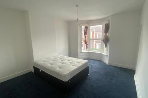 A bright double bedroom featuring a large bay w...