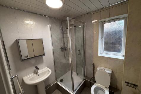 Bright bathroom with glass shower and window....