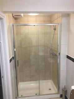 Tiled walk-in shower with sliding clear glass d...