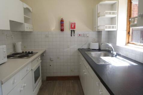 Bright galley kitchen with a window providing n...