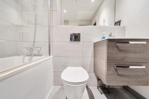 Modern bathroom suite with sleek tiling and bat...