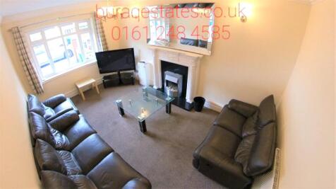 Spacious, well-lit living room with two comfort...