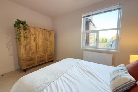 Bright, simply styled bedroom with a comfortabl...