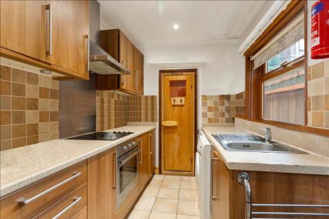 A well-equipped kitchen featuring modern wooden...