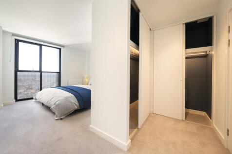 Experience modern elegance in this bright bedroom featuring a walk-in closet.